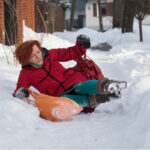 woman slips and falls on snowy sidewalk