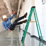 Construction worker in midst of falling off ladder