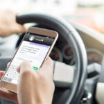 person holding cell phone while in the car