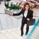 Young woman climbing stairs in business