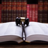 Close-up Of An Open Law Book And Wooden Mallet In Courtroom